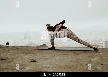 Young woman practicing yoga, stretching.Barcelona Stock Photo