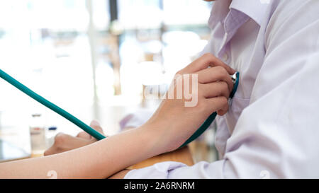 Doctor checking patient. Doctor examines a patient with a stethoscope. Health, Hospital and Medical concept. Stock Photo