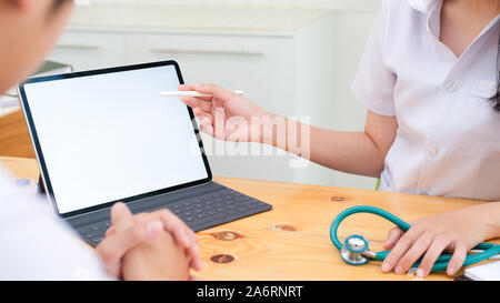 Doctor using tablet discussion something with patient. Health care , Hospital and Doctor concept. Copy space of blank computer and tablet screen. Stock Photo