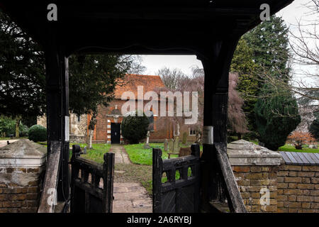 London, UK - March 17 2018: Entrance to St Dunstan's Church through a wooden gate, in Cranford Park. The oldest surviving part is its 15th-century tow Stock Photo