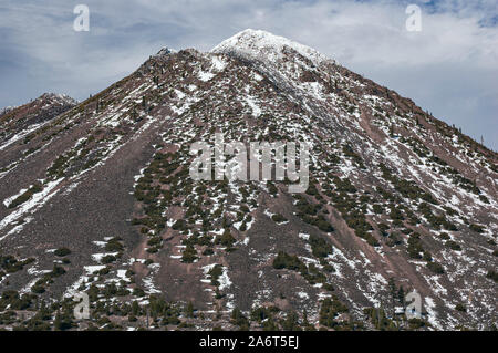 closup of the top of black butte a satellite lava cone dome of mount shasta in northern california showing lava, sparse vegetation mixed with snow Stock Photo