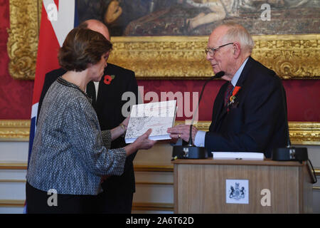 French Ambassador Catherine Colonna receives a gift from World War II veteran Geoffrey Pidgeon, who received the 6000th Legion d'honneur, for his role in the liberation of France during World War II, at a medal ceremony in Lancaster House in London. Stock Photo