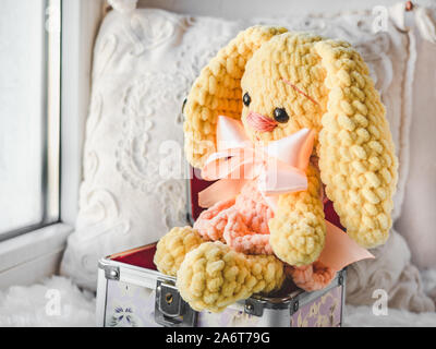 Beautiful, bright plush toy sitting on a windowsill on a clear, sunny day. Close-up, indoor. Day light Stock Photo