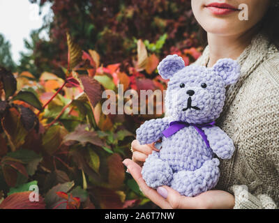 Pretty, young woman holding a stuffed toy in the background of yellow foliage. Close-up, outside Stock Photo