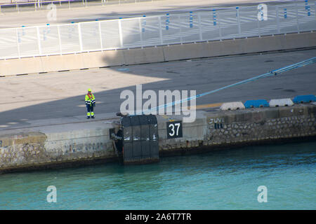 Mooring worker waiting for the signal to release the rope. Stock Photo