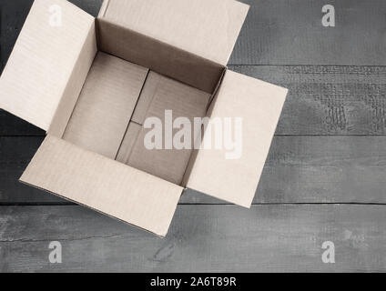 Cardboard box for postal items on a wooden background. Stock Photo