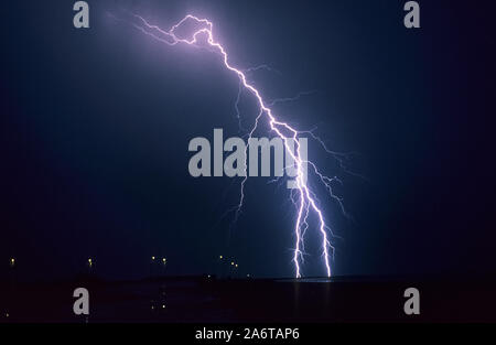 Long forked lightning bolt strikes down from a summer thunderstorm in Lake IJsselmeer, Netherlands Stock Photo