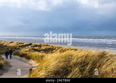 North Sea island Spiekeroog, East Frisia, in winter, hiker at the beachGermany Stock Photo