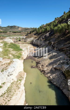 Because of scant rainfall late summer, low water levels expose an old roman bridge normally underwater. Iznajar Reservoir, Andalucia. Spain Stock Photo
