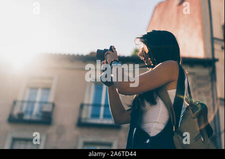 Female person with a bag making a picture with his reflex camera at sunset Stock Photo