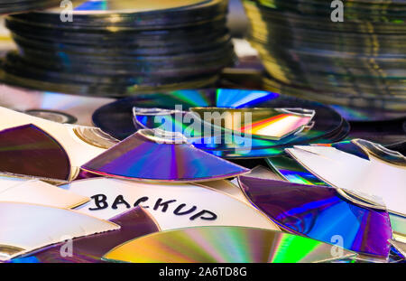Old compact discs. Secure backup. Disposal of digital secret personal data. Shredded discarded archiving media. Obsolete storage devices. E-waste heap. Stock Photo