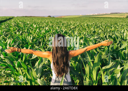 Female farmer in a landscaped corn field at sunset Stock Photo