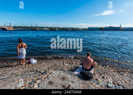 People taking sunbath on the beach near Peter and Paul Fortress in Saint Petersburg, Russia Stock Photo