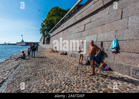 People taking sunbath on the beach near Peter and Paul Fortress in Saint Petersburg, Russia Stock Photo