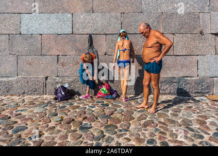 Family taking sunbath on the beach near Peter and Paul Fortress in Saint Petersburg, Russia Stock Photo