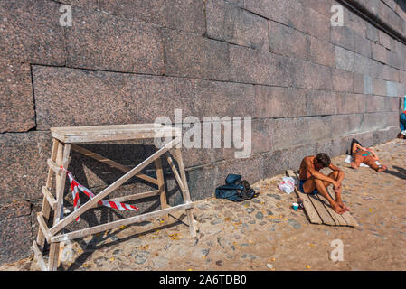 People taking sunbath on the beach near Peter and Paul Fortress in Saint Petersburg, Russia Stock Photo