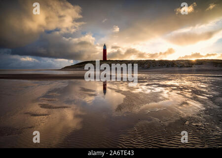 dramatic sunrise behind lighthouse on north sea coast Stock Photo