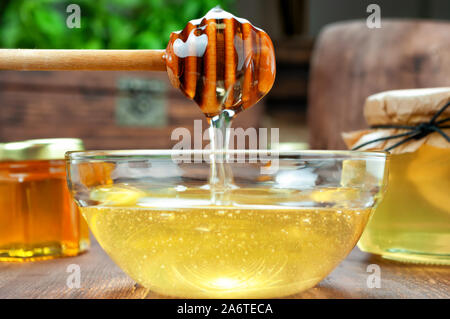 Honey dripping from honey dipper Stock Photo