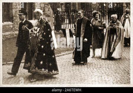 MAUNDAY  / MAUNDY MONEY  Circa 1940's - King George VI of England joins high ranking clergy and Queen Elizabeth his wife (walking behind) for the  the annual ceremony of distributing Maundy Money after the a religious service in the Church of England held on Maundy Thursday, the day before Good Friday when the British monarch ceremonially distributes small silver coins known as 'Maundy money' as symbolic alms Stock Photo