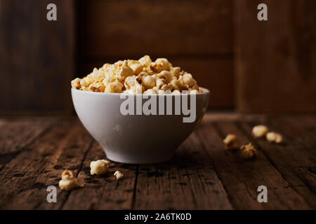 Delicious popcorn with caramel on wooden background. Stock Photo
