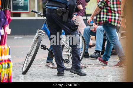 Worms, Germany. 24th Oct, 2019. A policeman checks a bicycle in the pedestrian zone of Worms. Credit: Andreas Arnold/dpa/Alamy Live News Stock Photo