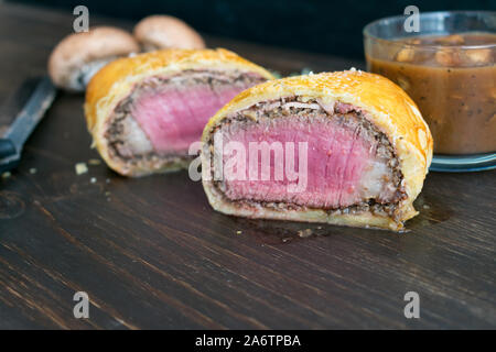 Individual Beef Wellington with Mushroom Sauce: Filet mignon wrapped in prosciutto ham, cremini mushroom, and puff pastry Stock Photo