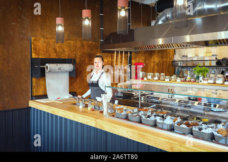 Successful small business owner looking at camera while standing behind counter in eatery Stock Photo