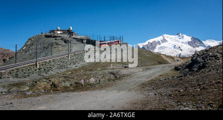 Gornergrat tourist train with the Dufourspitze in background. Dufourspitze is the highest mountain peak in Switz Stock Photo