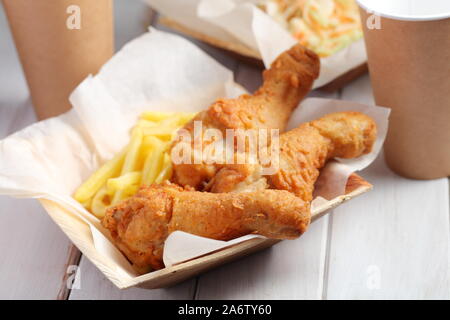 Fried chicken legs with French fries and cole slaw salad Stock Photo