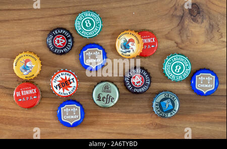 Beer caps of various traditional Belgian beers on old wooden table Stock Photo