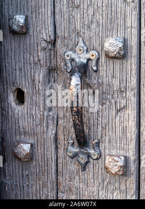 Closeup of old black iron door handle on studded black oak wood door, Old John Castle, Bradgate Park, Leicestershire, England, UK Stock Photo