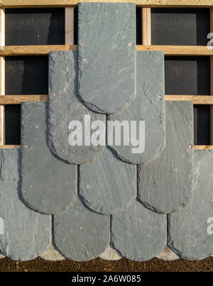 Closeup showing construction of nailed slate tiled roof with felt, tiles and wooden roofing laths / battens. Stock Photo