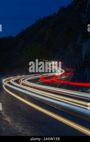 Hawks Nest Light Show - Car trails along the winding route 97 during the autumn foliage season in Sparrow Bush, New York. Stock Photo