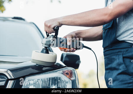 cropped view of car cleaner polishing car with buffer machine Stock Photo