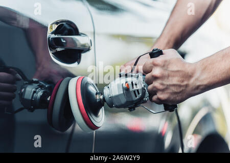 cropped view of car cleaner polishing car with buffer machine Stock Photo