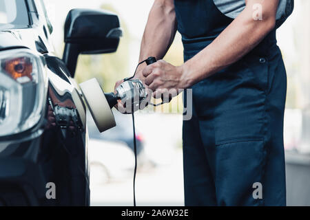 partial view of car cleaner polishing car with buffer machine Stock Photo