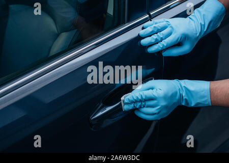 partial view of car cleaner polishing black car door handle Stock Photo