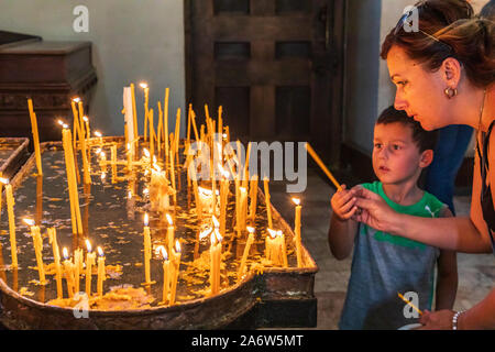 Armenia. Armavir Province. Vagharshapat. August 17, 2018. Worshipers lighting candles in the Mother See of Holy Etchmiadzin Church. Stock Photo