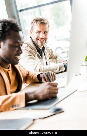 selective focus of two multicultural businessmen working together in office Stock Photo