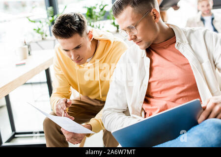 two young businessmen discussing startup project together in office Stock Photo