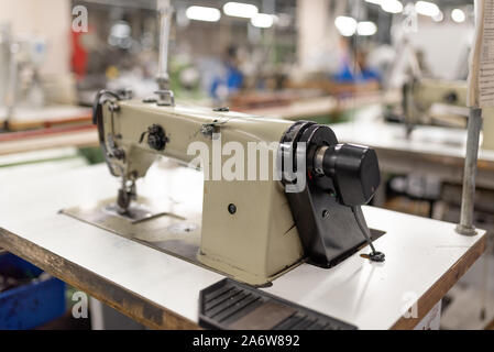 Industrial sewing machine in the work shop. Shoe manufacturing. Stock Photo