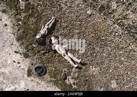 top view of scary and burnt baby dolls on ground, post apocalyptic concept Stock Photo