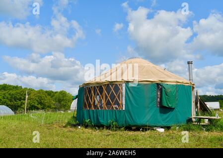 Traditional canvas yurt home with chimney at a small farm outside during sunny daytime in summer, in Decorah, Iowa, USA. Stock Photo