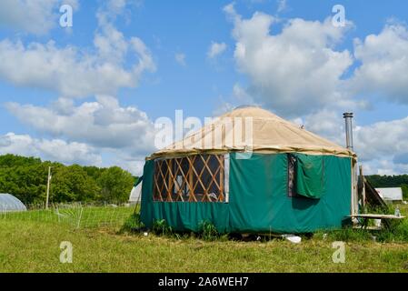 Traditional canvas yurt home with chimney at a small farm outside during sunny daytime in summer, in Decorah, Iowa, USA. Stock Photo