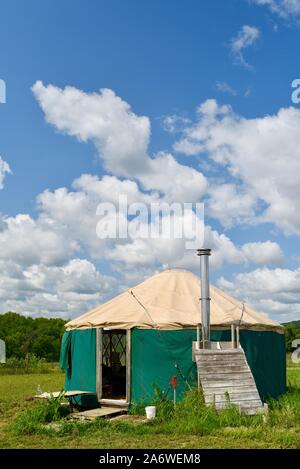 Traditional canvas yurt home with chimney at a small farm outside during sunny daytime in summer, in Decorah, Iowa, USA. Stock Photo