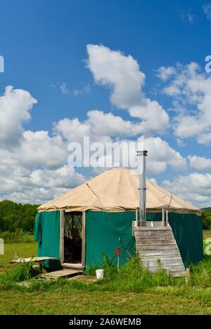 Traditional canvas yurt home with chimney at a small farm outside during sunny daytime in summer, in Decorah, Iowa, USA. Stock Photo