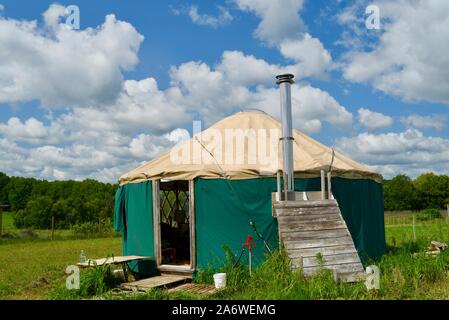 Traditional canvas yurt home with chimney at a small farm outside during sunny daytime in summer, in Decorah, Iowa, USA. Stock Photo