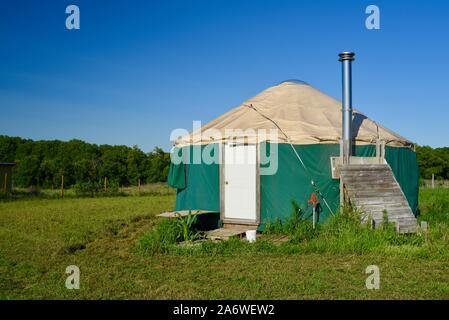 Traditional canvas yurt home with chimney at a small farm outside during sunny daytime in summer, in Decorah, Iowa, USA. Stock Photo