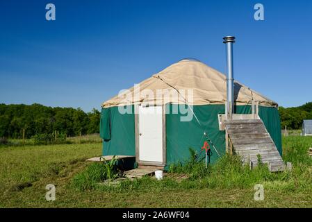 Traditional canvas yurt home with chimney at a small farm outside during sunny daytime in summer, in Decorah, Iowa, USA. Stock Photo