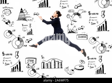 side view of beautiful businesswoman talking on smartphone while dancing near illustration with graphs ad charts isolated on white Stock Photo
